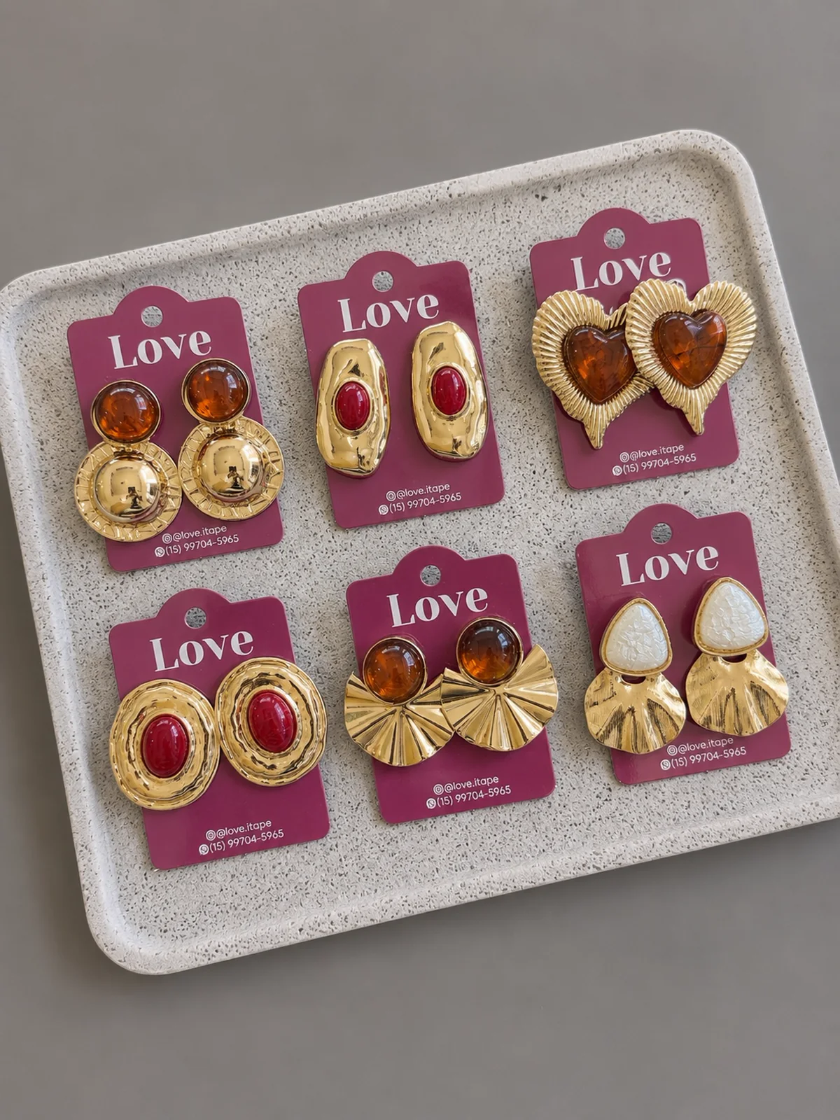 Brincos dourados sobre embalagens Love